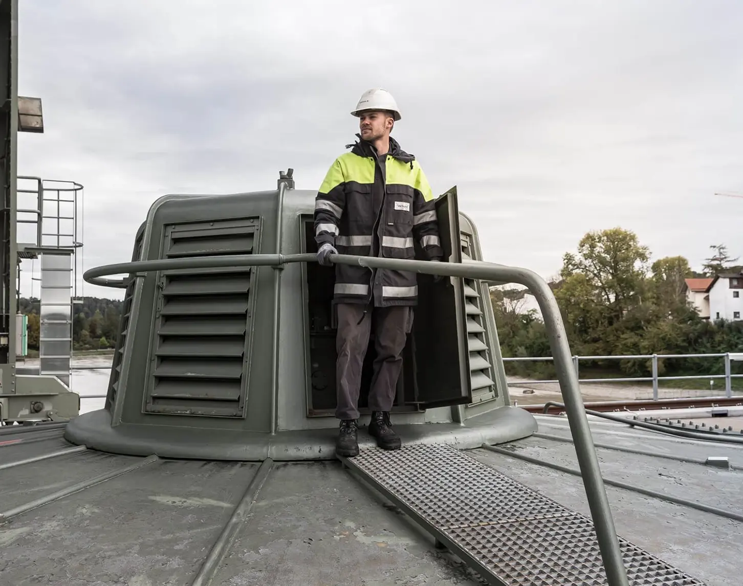 Ein VERBUND-Mitarbeiter in Sicherheitskleidung blickt im Kraftwerk Wasserburg nach links.