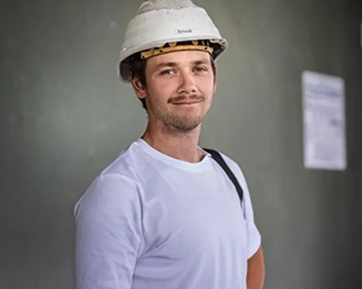 Das Bild zeigt ein Portraitbild von Robert Schiessl in weißem T-Shirt und weißem Sicherheitshelm.