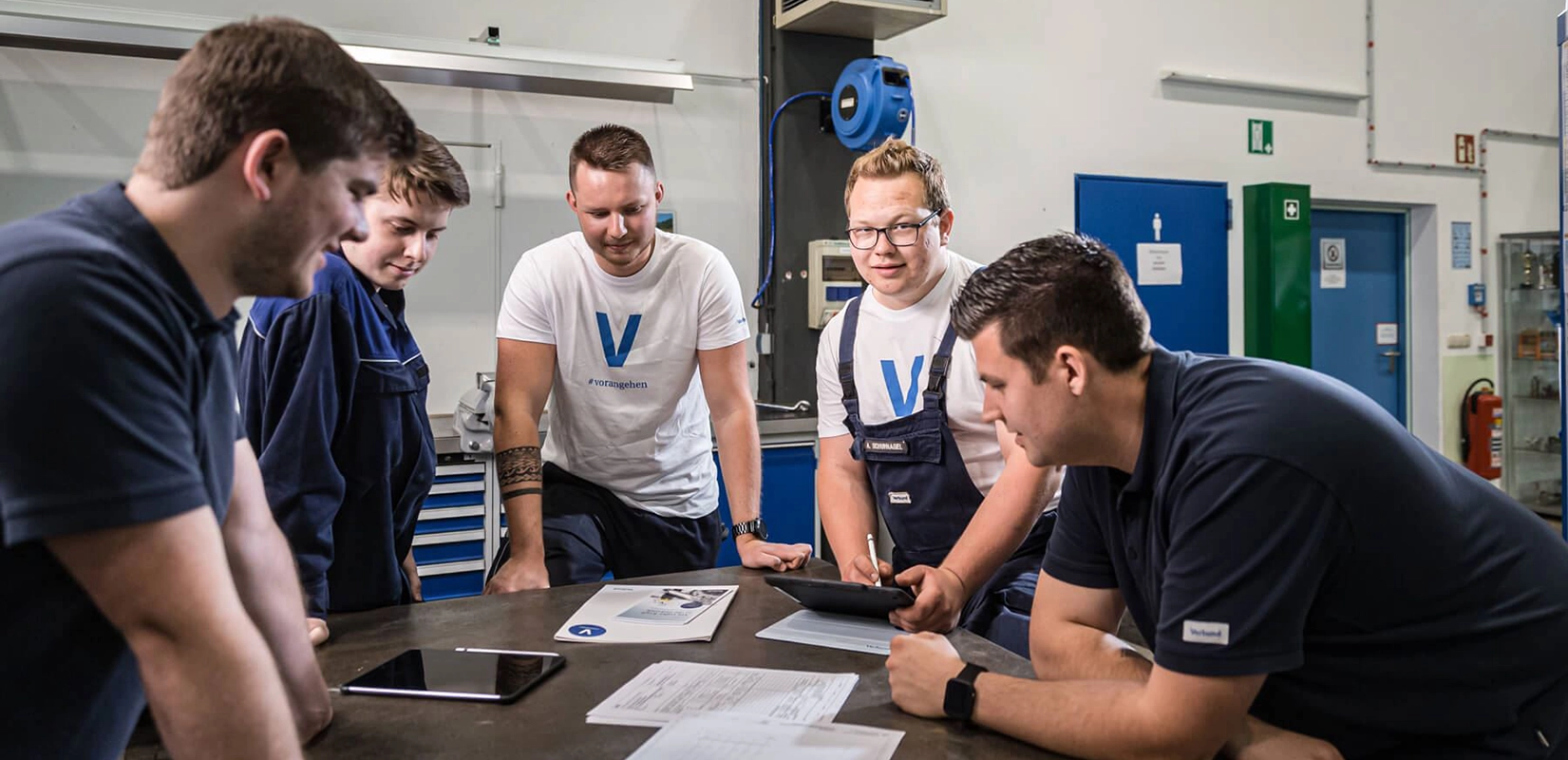 Eine Gruppe aus VERBUND-Lehrlingen bespricht sich mit ihrem Ausbilder in einem Wasserkraftwerk.